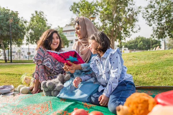 Dubai - anne kızları bir parkta birlikte eğleniyor mutlu Arap aile