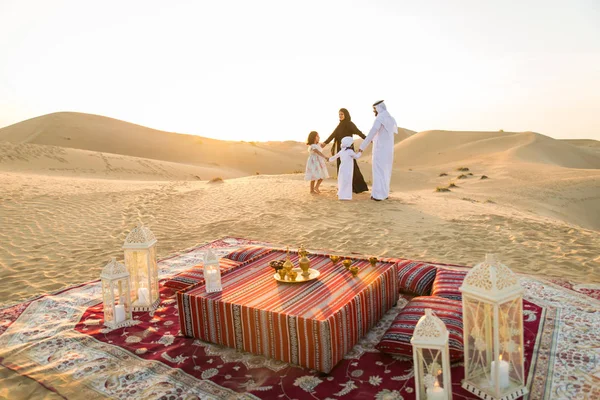 Arabian family with kids having fun in the desert - Parents and children celebrating holiday in the Dubai desrt