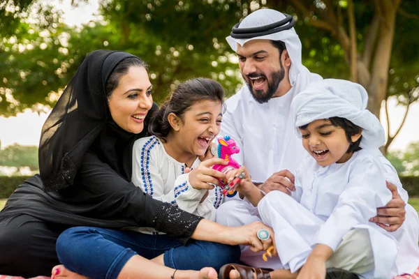 Dubai - ebeveynler ve çocuklar hafta sonu doğada kutluyor bir parkta eğleniyor mutlu bir Orta Doğulu aile