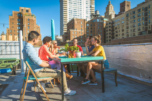 Молодые счастливые люди, ужинающие барбекю на крыше в Нью-Йорке - Группа друзей, весело проводящих время
