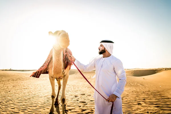 Kandura ve gatra bir deve çölde sürme ile Orta Doğu yakışıklı