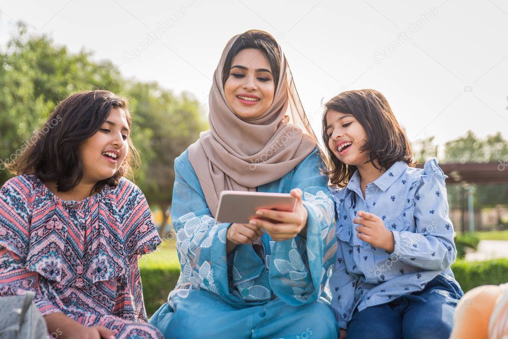 Happy arabian family having fun in Dubai - Mom together with her daughters in a park