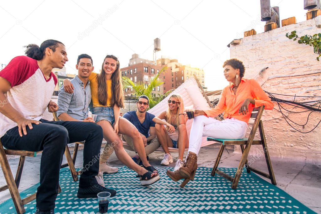 Young happy people having a barbecue dinner on a rooftop in New York - Group of friends having party and having fun