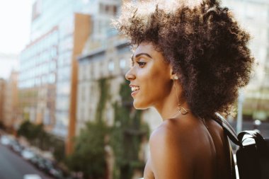 Gülümseyerek mutlu bir Afrikalı-Amerikalı kadın. Yürüyüş ve New York'ta eğleniyor güzel genç kadın