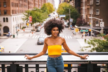Gülümseyerek mutlu bir Afrikalı-Amerikalı kadın. Yürüyüş ve New York'ta eğleniyor güzel genç kadın