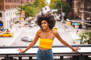 Gülümseyerek mutlu bir Afrikalı-Amerikalı kadın. Yürüyüş ve New York'ta eğleniyor güzel genç kadın