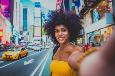 Gülümseyerek mutlu bir Afrikalı-Amerikalı kadın. Yürüyüş ve New York'ta eğleniyor güzel genç kadın