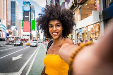 Gülümseyerek mutlu bir Afrikalı-Amerikalı kadın. Yürüyüş ve New York'ta eğleniyor güzel genç kadın