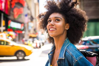 Gülümseyerek mutlu bir Afrikalı-Amerikalı kadın. Yürüyüş ve New York'ta eğleniyor güzel genç kadın
