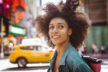 Gülümseyerek mutlu bir Afrikalı-Amerikalı kadın. Yürüyüş ve New York'ta eğleniyor güzel genç kadın