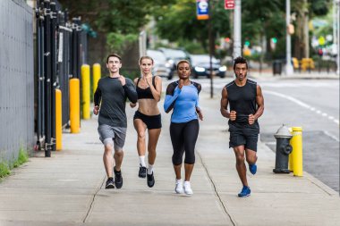 Çok etnik gruptan oluşan grup koşucu açık havada - sportif insanlar spor ve sağlıklı yaşam hakkında kavramları Manhattan, sokakta çalışan eğitim