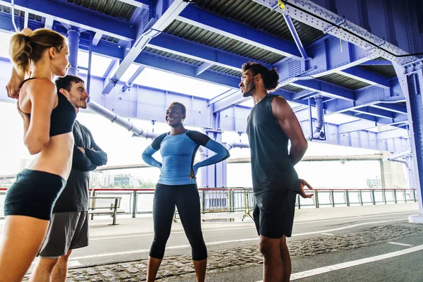 Multi-ethnic group of runners training outdoors - Sportive people running on the street of Manhattan, concepts about sport and healthy lifestyle