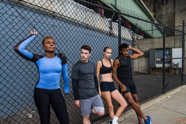 Multi-ethnic group of runners training outdoors - Sportive people running on the street of Manhattan, concepts about sport and healthy lifestyle