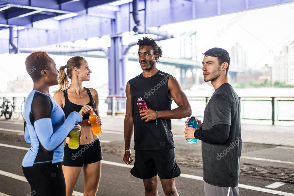 Multi-ethnic group of runners training outdoors - Sportive people running on the street of Manhattan, concepts about sport and healthy lifestyle