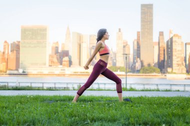 Kadın parkta yoga yapıyor.