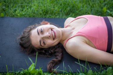 Kadın parkta yoga yapıyor.