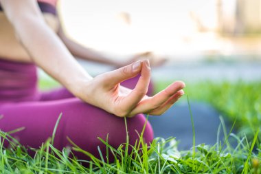 Kadın parkta yoga yapıyor.