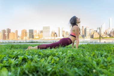 Kadın parkta yoga yapıyor.