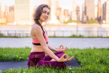 Kadın parkta yoga yapıyor.