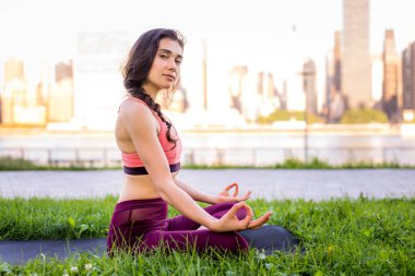 Kadın parkta yoga yapıyor.