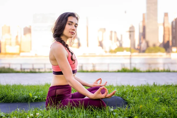 Kadın parkta yoga yapıyor.