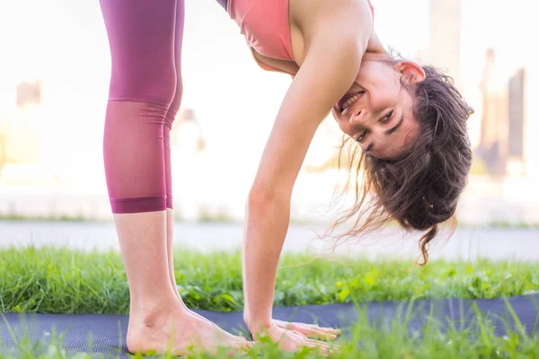 Kadın parkta yoga yapıyor.