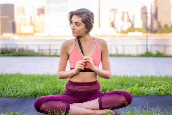 Kadın parkta yoga yapıyor.