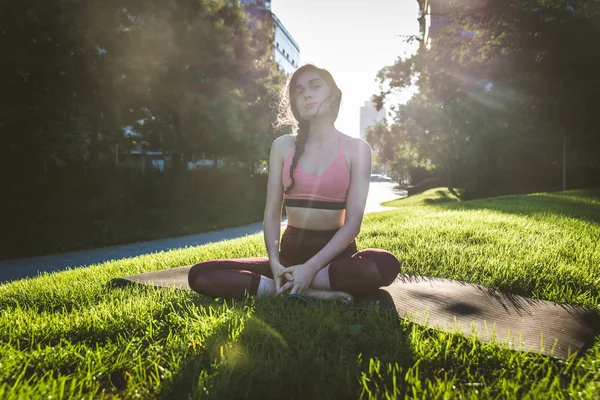 Kvinna som gör yoga i en park — Stockfoto