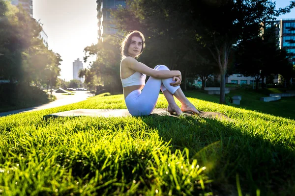 Kvinna som gör yoga i en park — Stockfoto