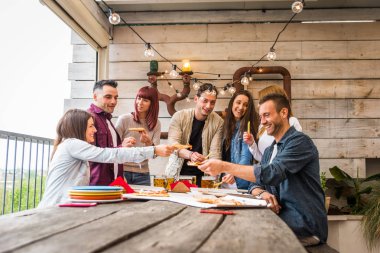 Evde mutlu arkadaşlar bağlama grubu-genç yetişkinler öğle yemeği ve birlikte bir çatı terasında vakit geçirmek, pizza ve atıştırmalıklar yeme