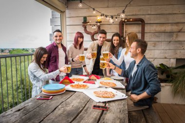 Evde mutlu arkadaşlar bağlama grubu-genç yetişkinler öğle yemeği ve birlikte bir çatı terasında vakit geçirmek, pizza ve atıştırmalıklar yeme