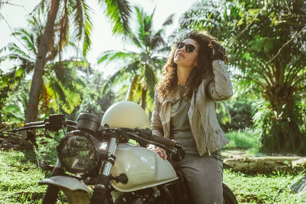 Motociclista mujer conduciendo una moto racer café — Foto de Stock