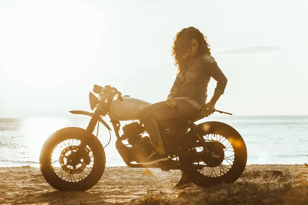 Motociclista mujer conduciendo una moto racer café —  Fotos de Stock