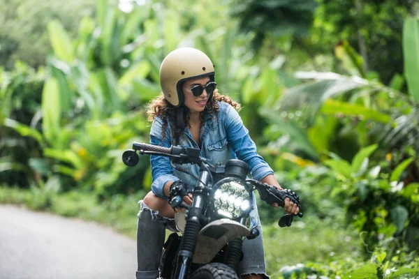 Motociclista mujer conduciendo una moto racer café — Foto de Stock