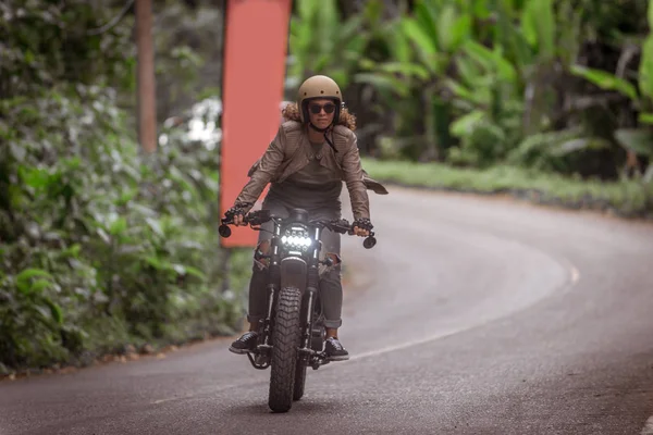 Vrouwelijke Biker rijden een café ' racer motor — Stockfoto