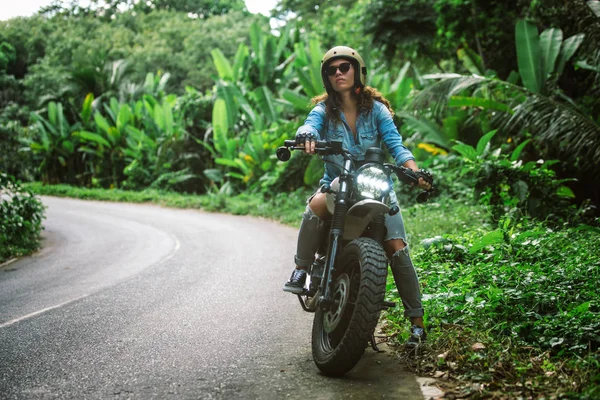 Motociclista mujer conduciendo una moto racer café — Foto de Stock