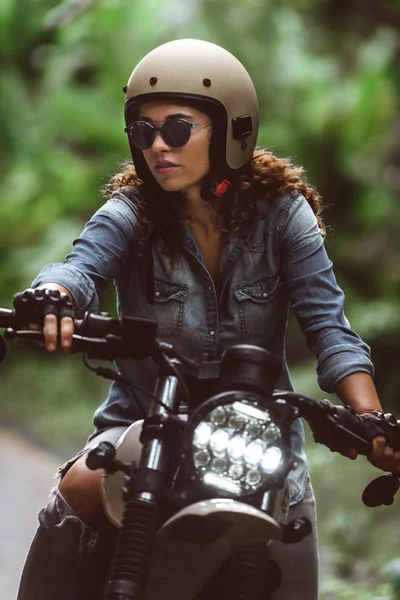 Motociclista mujer conduciendo una moto racer café — Foto de Stock