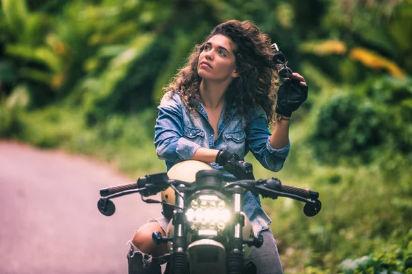 Motociclista mujer conduciendo una moto racer café — Foto de Stock