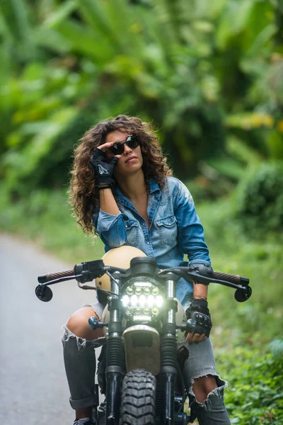 Motociclista mujer conduciendo una moto racer café —  Fotos de Stock