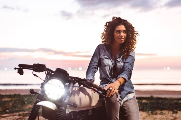 Motociclista mujer conduciendo una moto racer café — Foto de Stock