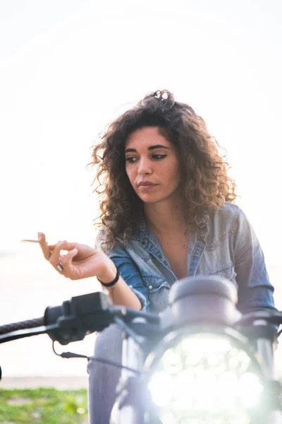 Motociclista mujer conduciendo una moto racer café — Foto de Stock