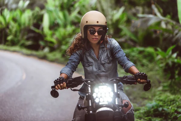 Motociclista mujer conduciendo una moto racer café — Foto de Stock