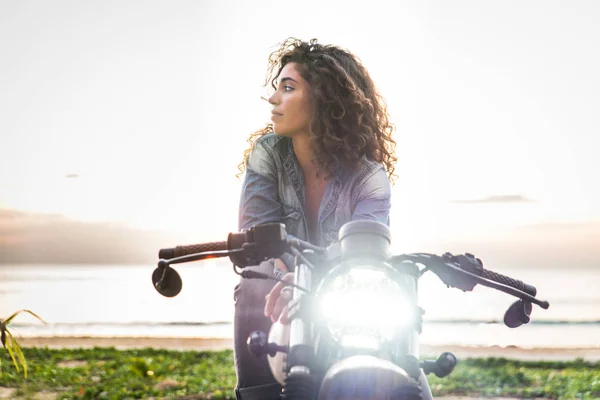 Female biker driving a cafe' racer motorbike