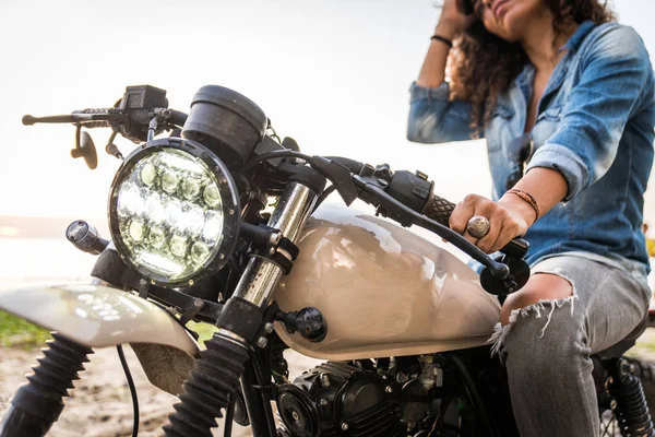 Motociclista mujer conduciendo una moto racer café —  Fotos de Stock