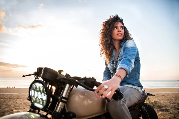 Motociclista mujer conduciendo una moto racer café —  Fotos de Stock