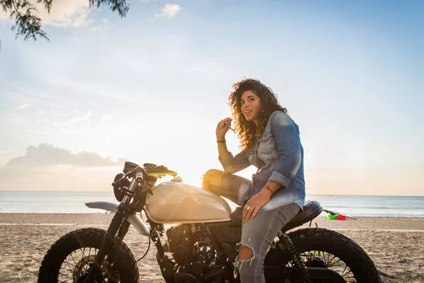 Motociclista mujer conduciendo una moto racer café —  Fotos de Stock