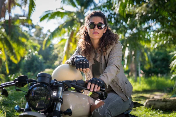 Female biker driving a cafe' racer motorbike