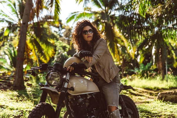 Female biker driving a cafe' racer motorbike