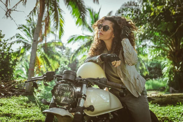 Motociclista mujer conduciendo una moto racer café — Foto de Stock