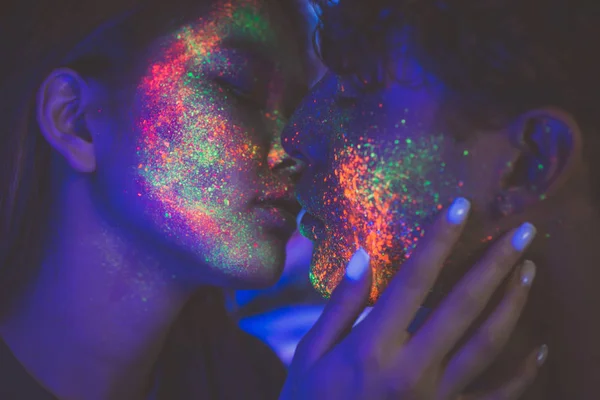 Couple kissing in the disco club with fluorescent paintings on t — Stock Photo, Image